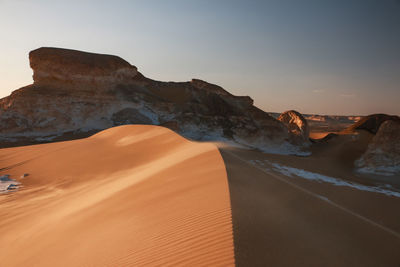 Scenic view of desert against sky during sunset