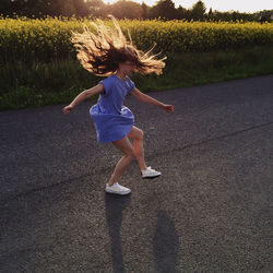 Teenage girl jumping on road