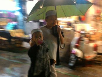 Blurred motion of woman walking on street in rain