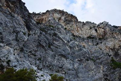 Low angle view of rocky mountains against sky