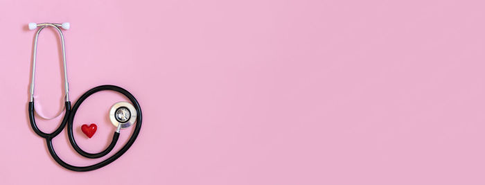 Close-up of stethoscope against pink background