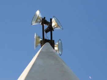 Low angle view of camera against clear blue sky