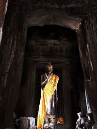 Man standing by sculpture in building