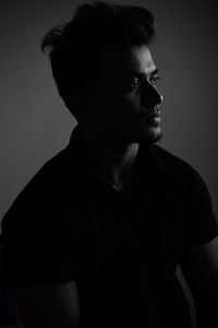 Close-up of young man looking away against wall