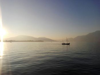 Boat sailing in sea at sunset