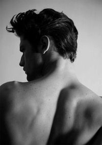 Rear view of shirtless man against white background
