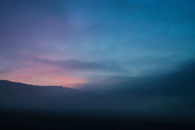 Scenic view of silhouette mountain against dramatic sky