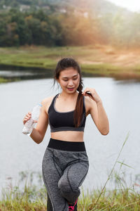 Young woman exercising at lakeshore