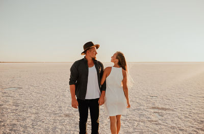 Portrait of smiling couple standing at beach
