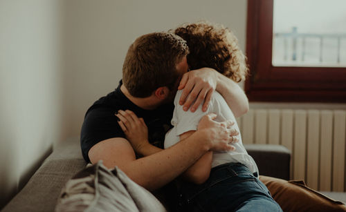 Rear view of father and daughter sitting on floor