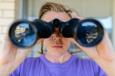 Close-up of man using binoculars