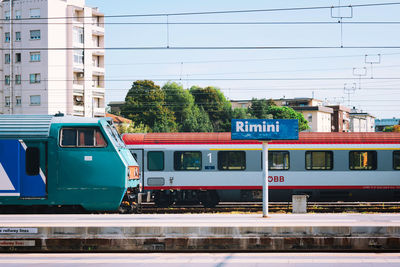 Train on railroad tracks in city against sky