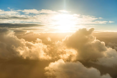 Low angle view of sunlight streaming through clouds