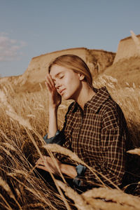 Full length of young woman sitting on rock