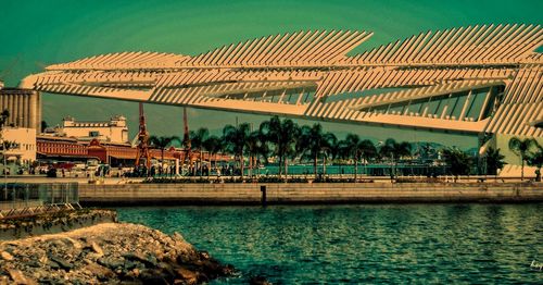 Bridge over river against sky in city