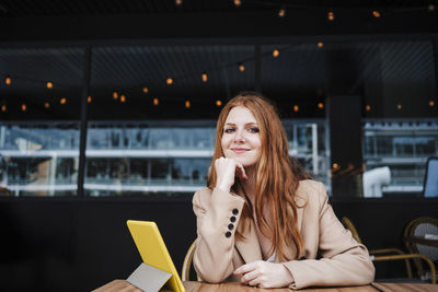 Portrait of a smiling young woman sitting outdoors