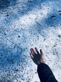 Low angle view of human hand against rippled water