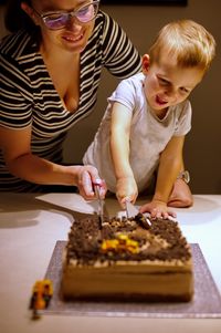 Mother and son cutting birthday cake