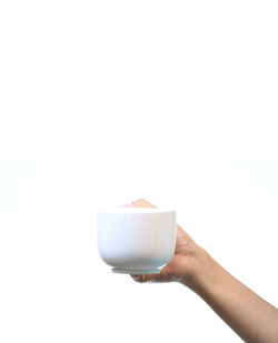 Hand holding coffee cup against white background