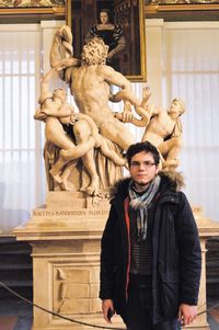 Portrait of man standing against statue