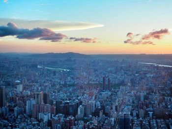 High angle view of modern buildings in city against sky during sunset