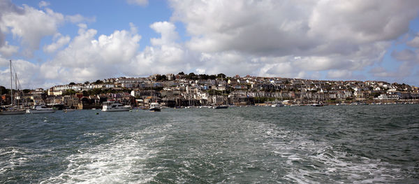 Panoramic shot of buildings by sea against sky