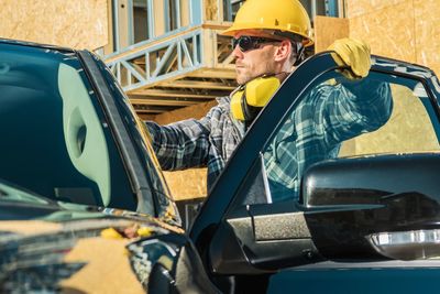 Side view of man working in car