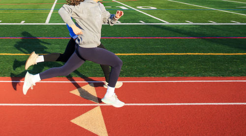 Low section of woman exercising on playing field
