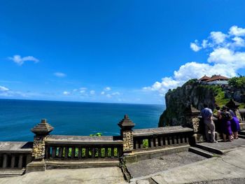 People looking at sea against sky