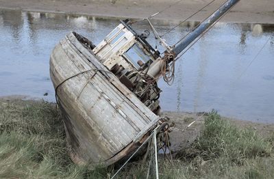 Abandoned boat moored at lakeshore