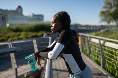 Black runner with water resting on embankment