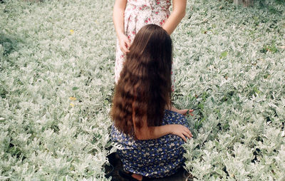 Girls amidst plants on field