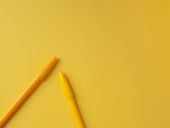 High angle view of pencils against yellow background