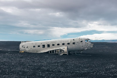 Abandoned airplane on runway against sky