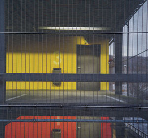 Close-up of yellow building seen through glass window