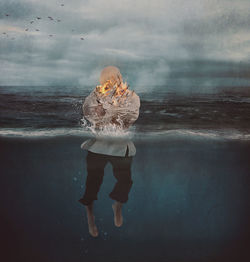 Digital composite image of man standing in sea