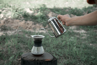 Close-up of hand holding bread on field