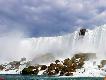 Scenic view of waterfall against sky