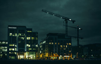 Low angle view of illuminated crane at night