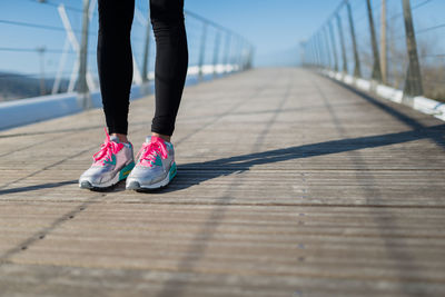 Low section of woman standing on footpath