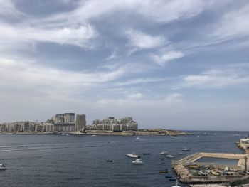 Scenic view of sea by buildings against sky