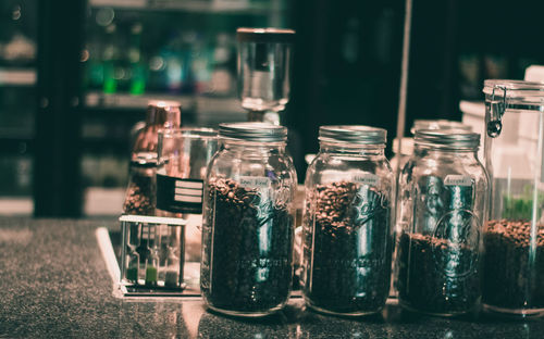 Coffee beans in jars on table