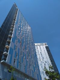 Low angle view of modern buildings against clear blue sky