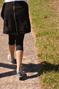 Low section of woman walking on footpath