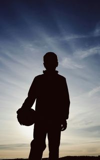 Silhouette of photographer against cloudy sky