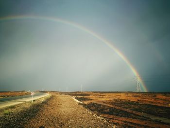 Scenic view of rainbow over road against sky