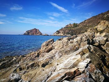 Scenic view of sea by cliff against sky