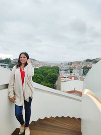 Portrait of young woman standing against sky