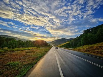 Road passing through landscape against sky