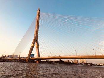 Suspension bridge over river against sky